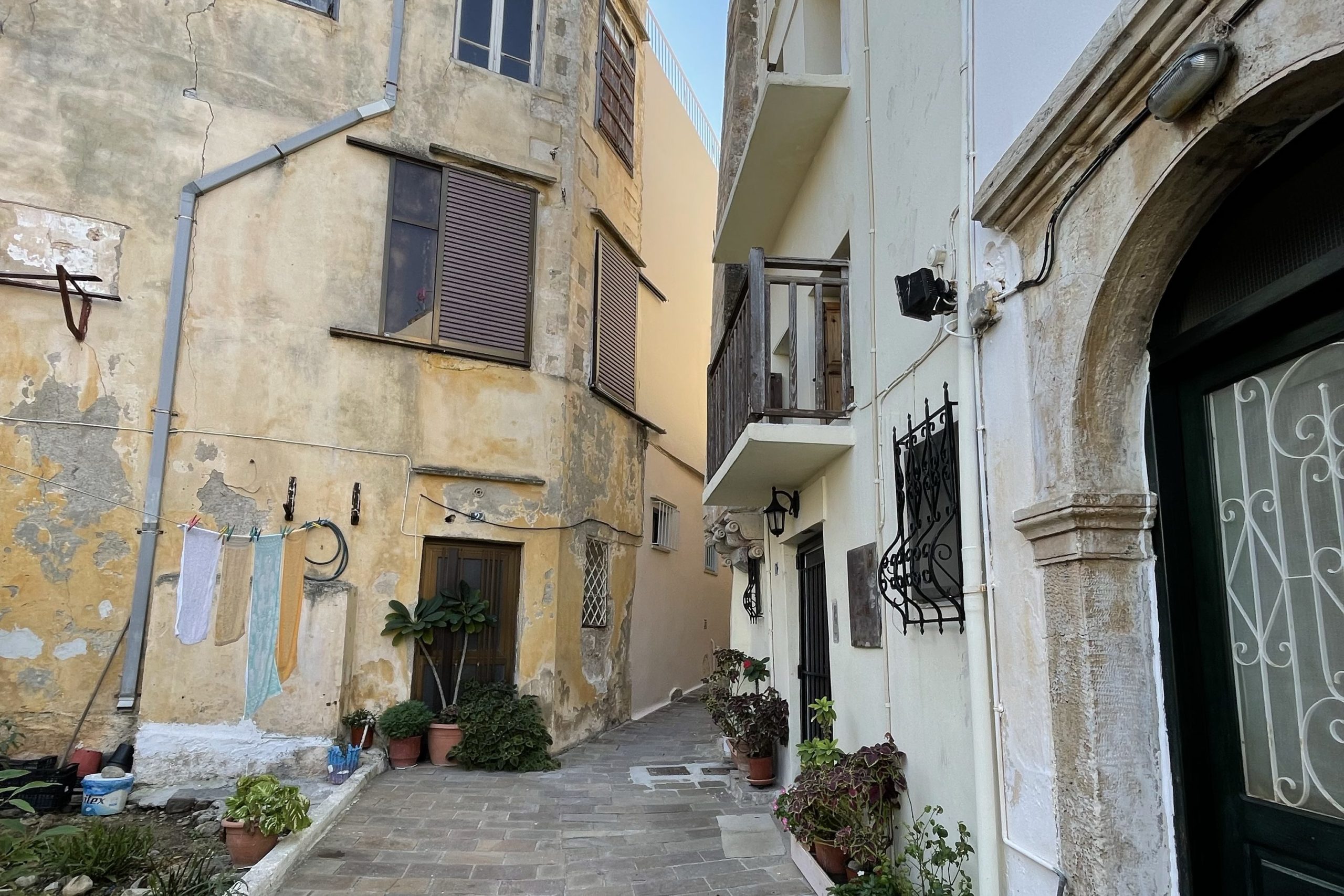 Une petite rue en Crète avec la facade en pierre blanche du studio Ashtanga Yoga Crete